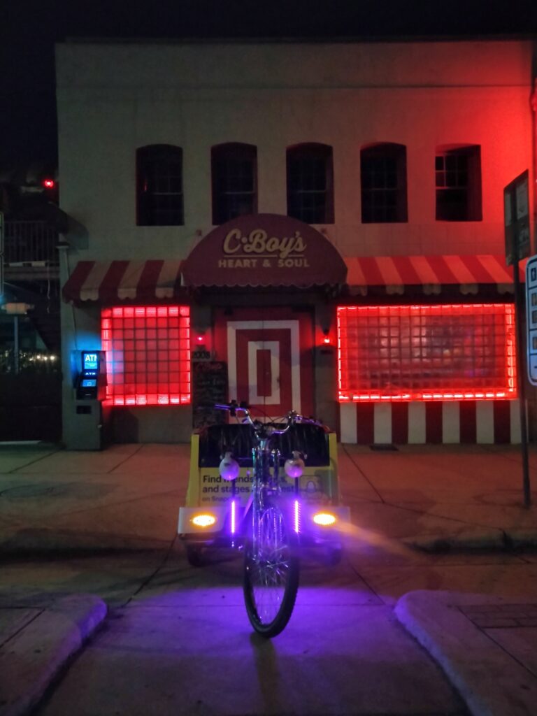 A pedicab parked in front of C-boys