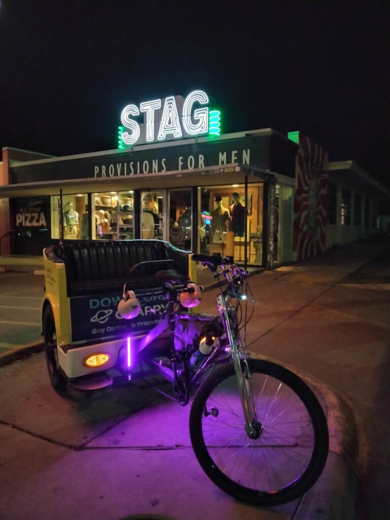 A pedicab parked in front of the store Stag.